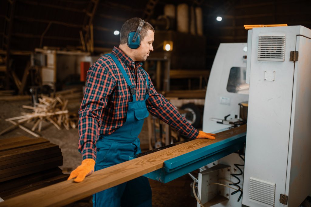 Woodworker works on machine, lumber industry